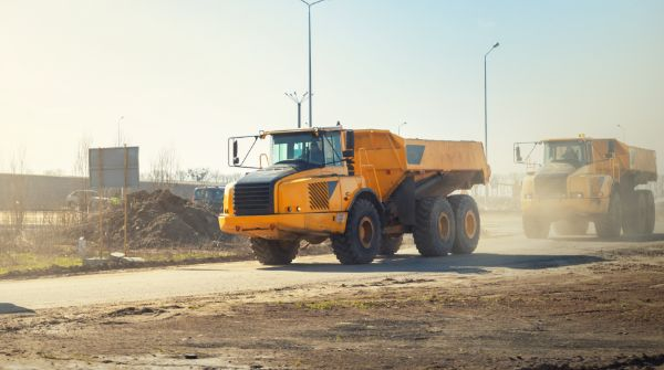 Heavy haul yellow truck on dirt road