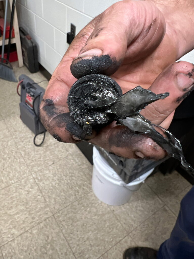 A broken piece of the pinion gear became attached to the drain plug